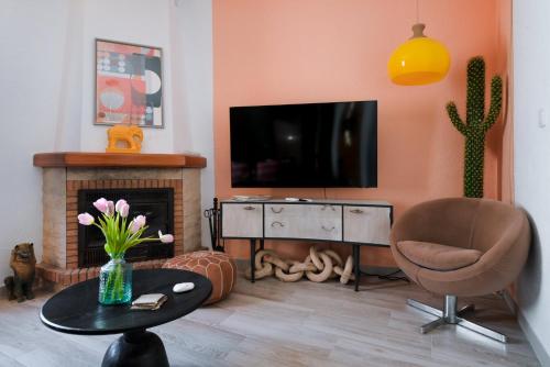uma sala de estar com uma televisão, uma cadeira e uma mesa em Romance 2 Terraza con Vistas al Mar by Vero em Altea