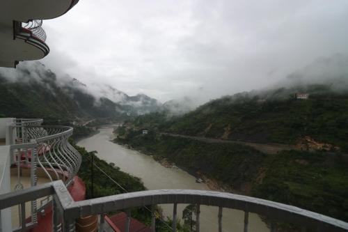 Una vista de un río con montañas al fondo. en Hotel Mandakini, en Rudraprayāg