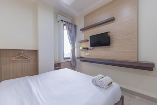 a hotel room with a bed and a tv at Urbanview Hotel Mamifokobo Puncak in Sindanglaya