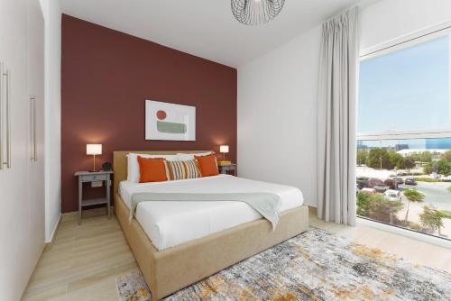 ein Schlafzimmer mit einem großen Bett und einem großen Fenster in der Unterkunft Maison Privee - Exquisite Apt on Yas Island cls to ALL attractions in Abu Dhabi