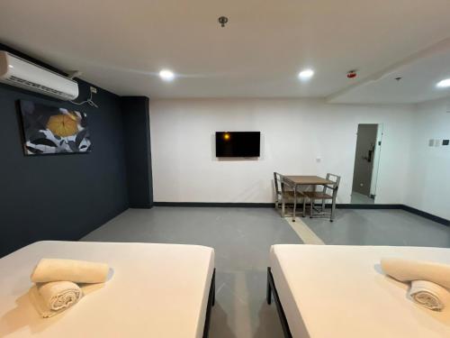 a room with two tables and a tv on a wall at Maine City Residences Tramo in Manila