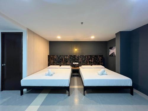 Dos camas en una habitación con dos en Maine City Residences Tramo, en Manila