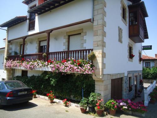 a white building with flowers on a balcony at Montañes in Santillana del Mar