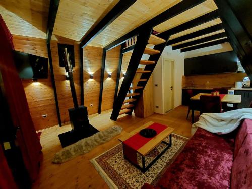 uma sala de estar com uma escada em espiral numa casa em Vilat Alpine Golden Gjinar em Elbasani