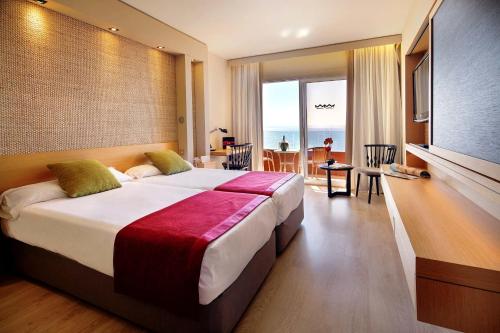 a bedroom with a large bed with a view of the ocean at Palace Bonanza Playa Resort & SPA by Olivia Hotels Collection in Illetas