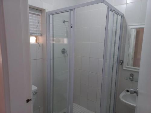 a bathroom with a shower and a toilet and a sink at 13 Bronze Bay in Durban