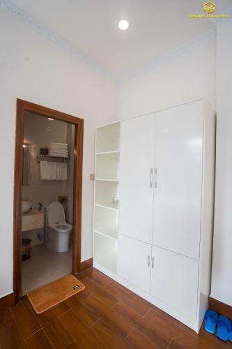 a bathroom with white cabinets and a toilet at Hoàng Gia Hotel Tuy Hoà in Tuy Hoa