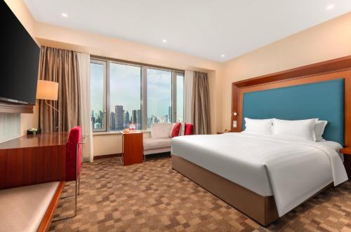 a hotel room with a bed and a large window at Novotel Atlantis Shanghai in Shanghai