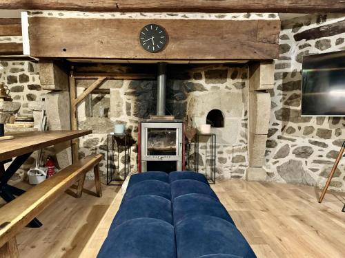 a living room with a blue couch in front of a stone wall at Le Quatorze 