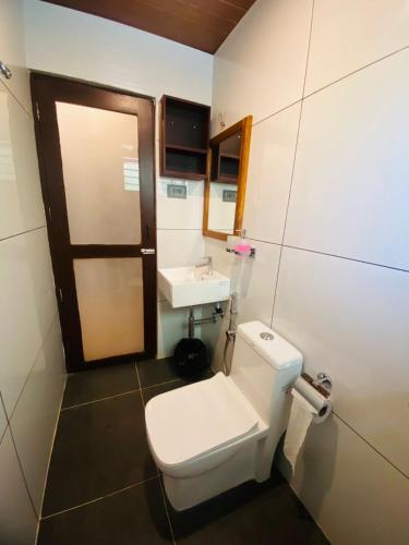 a bathroom with a toilet and a sink at Hotel Holiday Home in Kovalam