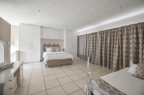 a bedroom with a bed and curtains in a room at 9 on Dolfyn in Yzerfontein