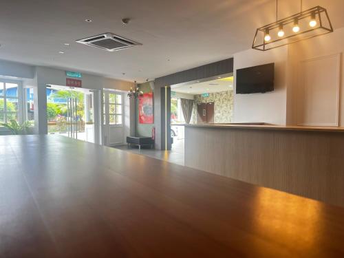 an empty lobby with a large wooden table and a bar at SiN LiEN HOTEL in Kluang