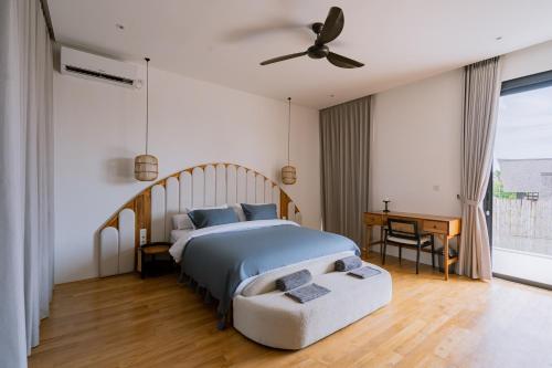 Unity Villas Canggu في تشانغو: غرفة نوم بسرير ومروحة سقف