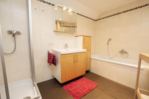 ein Badezimmer mit einem Waschbecken, einer Badewanne und einer Dusche in der Unterkunft Ferienwohnung Nagelschmied in Radstadt