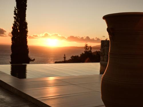 a sunset over the ocean with a vase at Thelxi's Suite I - Brand New Seaview Suite! in Agios Nikolaos