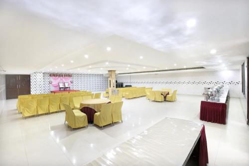 uma sala de jantar com cadeiras e mesas amarelas num quarto em Hotel Inderprasth em Ābādpura