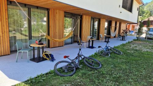 dos bicicletas estacionadas en el césped fuera de un edificio en Guesthouse Na trati en Črna na Koroškem