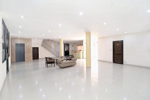 Sala de estar blanca con sofá y mesa en Hotel Inderprasth en Ābādpura