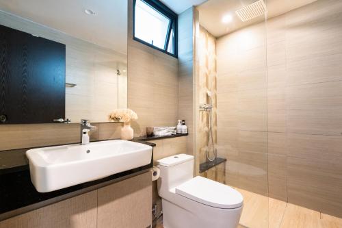 a bathroom with a white sink and a toilet at DingD0ng Home FelizEnVista 5-star facilities in Ho Chi Minh City
