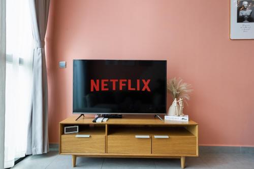 a flat screen tv sitting on top of a wooden cabinet at DingD0ng Home FelizEnVista 5-star facilities in Ho Chi Minh City