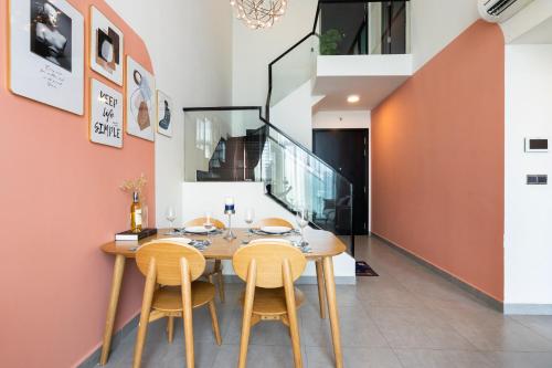 a dining room with a wooden table and chairs at DingD0ng Home FelizEnVista 5-star facilities in Ho Chi Minh City