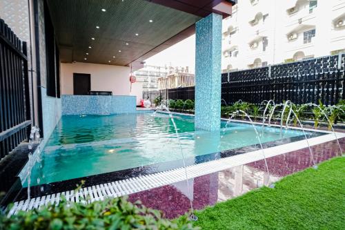 a swimming pool with a fountain in the middle of a building at Rupasi Bangla-lll in Digha