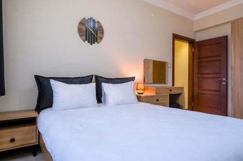 een slaapkamer met een groot wit bed en een televisie bij Flat w Balcony 5 min to Metro and Coast in Izmir in Izmir