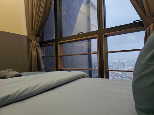 a bed in a room with a large window at Icon Residenz Icon City, Petaling Jaya by De Harlequins Guesthouse in Petaling Jaya