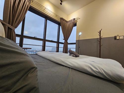 a large bed in a room with a large window at Icon Residenz Icon City, Petaling Jaya by De Harlequins Guesthouse in Petaling Jaya