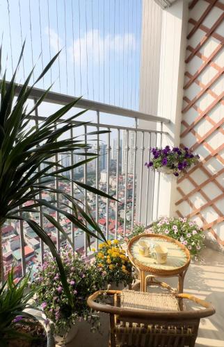 - un balcon avec une table, des chaises et des fleurs dans l'établissement A delightful Vinhomes Times City apartment, à Hanoï