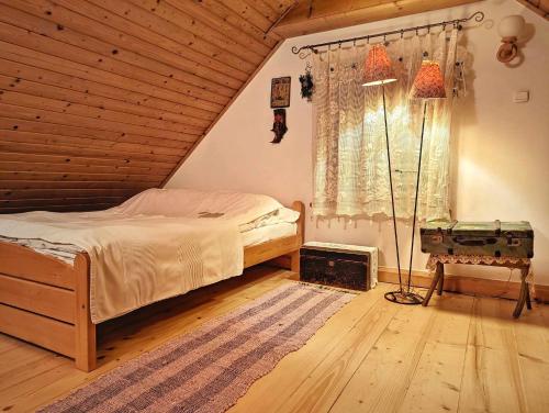 um quarto com uma cama e um tecto de madeira em Góralska Chata Bystre z 1863r em Istebna
