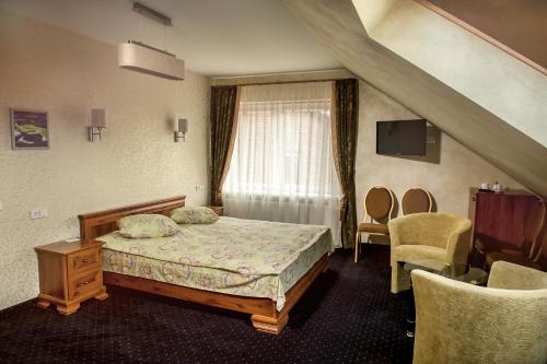 a bedroom with a bed and a window and chairs at Patalpų nuoma Žasliuose in Žasliai
