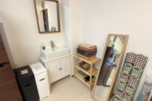 a bathroom with a sink and a mirror and a refrigerator at 1min walk to sta, drct bus to HND! Easy access! 03 in Tokyo