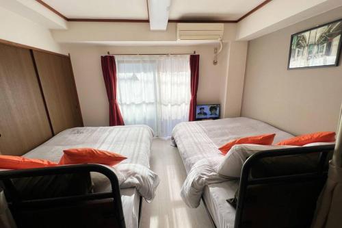 Duas camas num pequeno quarto com uma janela em 1min walk to sta, drct bus to HND! Easy access! 03 em Tóquio