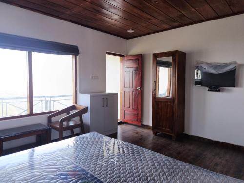 sypialnia z łóżkiem, biurkiem i oknem w obiekcie My Kingdom Munnar w mieście Munnar