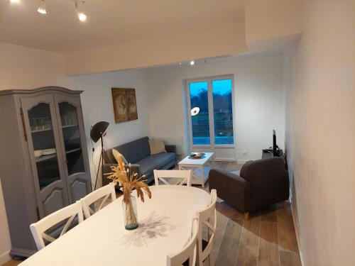 uma sala de estar com uma mesa e um sofá em Maison bretonne em Plourhan