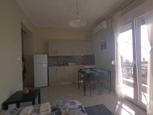 a kitchen with a table and a refrigerator at Katerina apartment in Nea Plagia