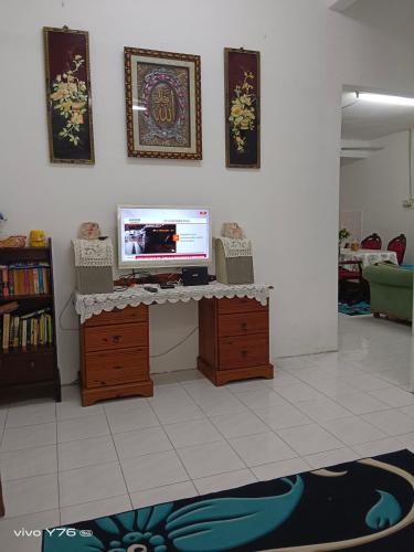 De' Aman Homestay في جيترا: غرفة معيشة مع تلفزيون على طاولة