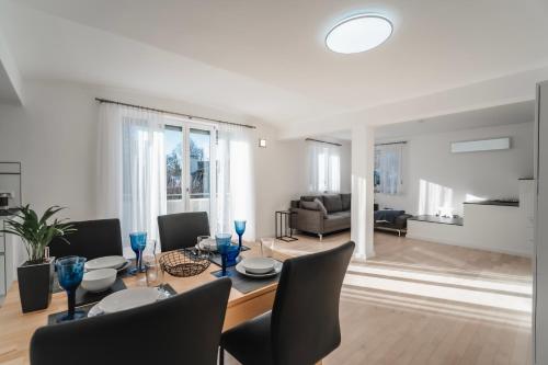 a dining room and living room with a table and chairs at Ferienwohnung am Starnberger See in Feldafing