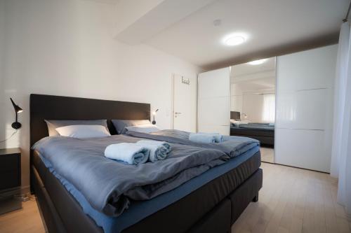 a bedroom with a large bed with blue towels on it at Ferienwohnung am Starnberger See in Feldafing