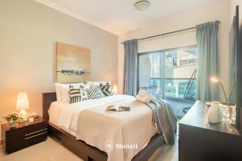 a bedroom with a large bed and a window at Manzil - 1BR Home in Dubai Marina with Marina View, Nr JBR Beach & Marina Mall in Dubai