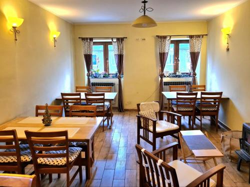 a restaurant with wooden tables and chairs and windows at Pansion Potok (kod Suzi) in Vrata