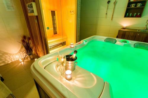 baño con bañera verde con velas en Villa Aina Boutique Hotel, en Laško