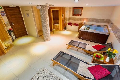 Villa Aina Boutique Hotel في لاشكو: غرفة مع حوض استحمام وطاولة وكراسي
