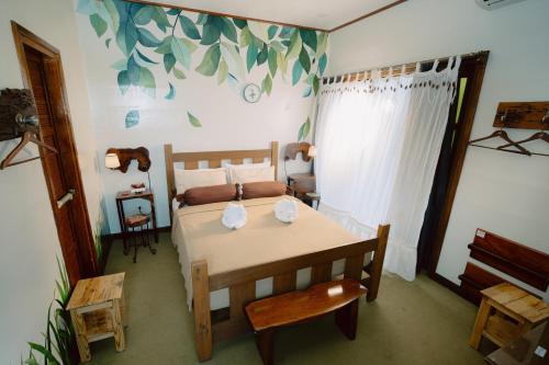 a bedroom with a bed and a table and chair at Antonio's Bed and Breakfast Hotel in Balogo