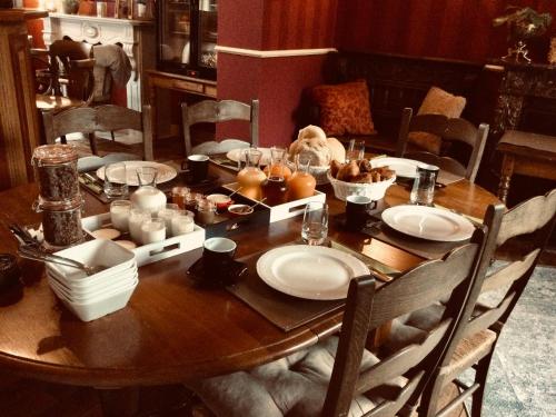 una mesa de madera con platos de comida. en L'auberge en Baronville