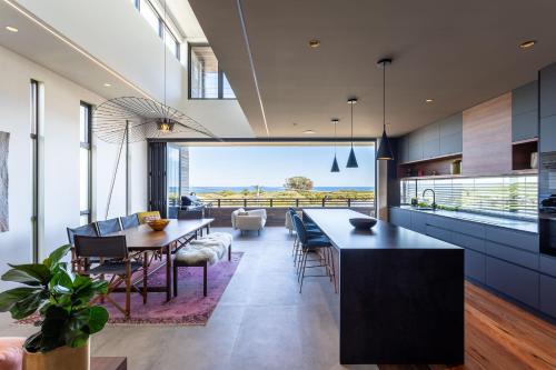 a kitchen and dining room with a view of the ocean at Stone & Wood I Private Properties in Yallingup