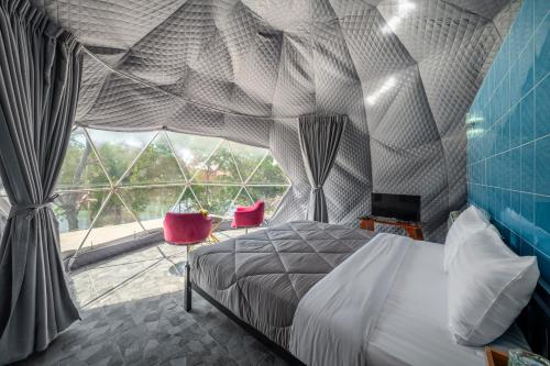 um quarto com uma cama e uma grande janela em Pran Riverside em Ban Tha Khoi