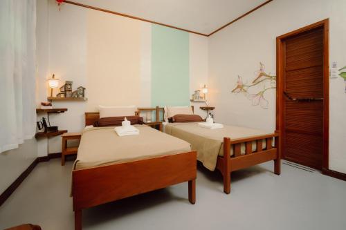 a room with two beds and a table in it at Antonio's Bed and Breakfast Hotel in Balogo