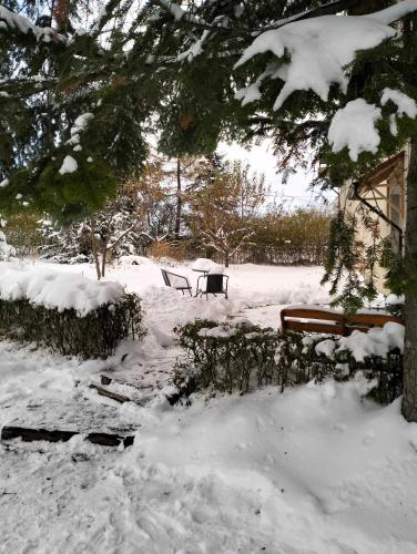 a snow covered park with benches and a table at Na początku in Budzów